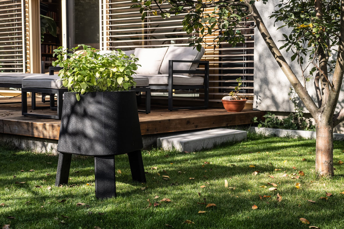 Black AYTO used as a raised garden bed with herbs on a lawn