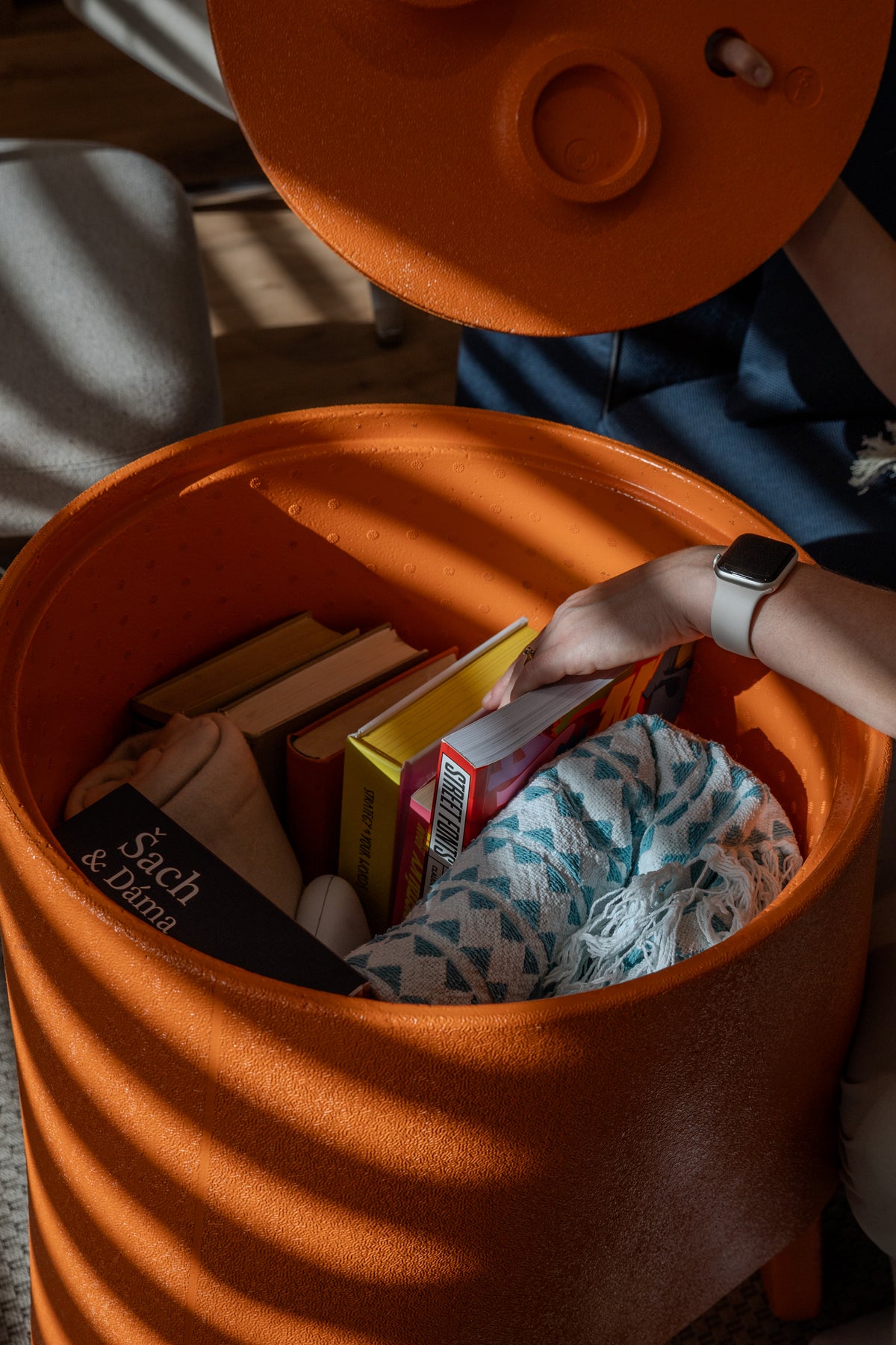 Top view into an open orange AYTO used as a storage box for toys and books