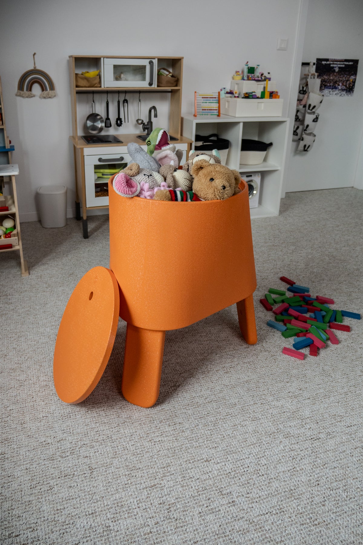 Orange AYTO with the lid set aside, used as a toy box in a children's room
